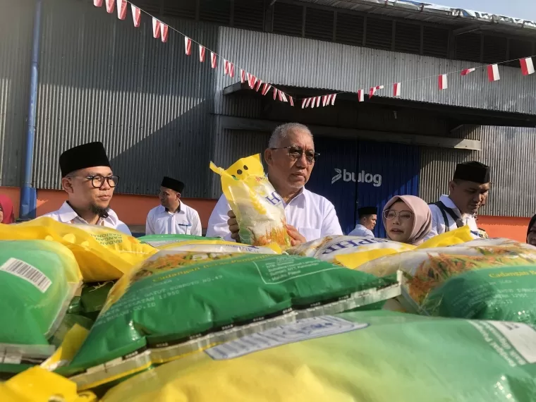 Direktur Utama Perum Bulog Bayu Krisnamurthi memperlihatkan beras yang akan didistribusikan.