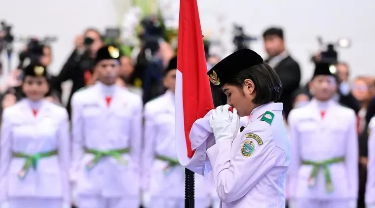 Anggota Paskibraka Putri memegang bendera merah putih