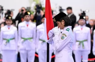 Anggota Paskibraka Putri memegang bendera merah putih