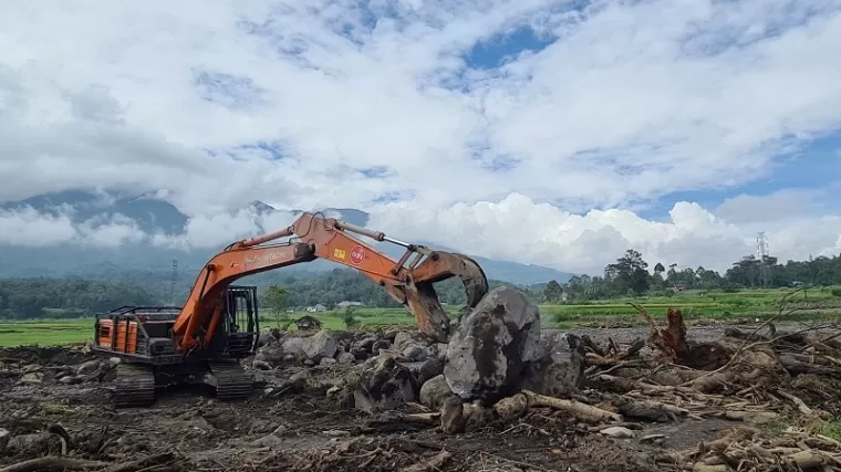 Alat berat dikerahkan guna membersihkan material bebatuan di wilayah Simpang Bukit Batiuah pada Jumat (21/5).