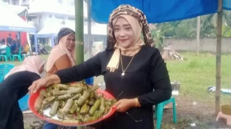 LAMANG TUNGKEK - Ibu ini tengah membawa Lamang Tungkek yang diperlombakan membuatnya di Festival Budaya Desa Talawi Hilie.(armadison)