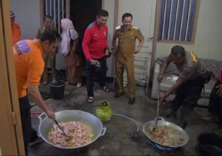 Petugas tengah memasak di dapur umum menyediakan makanan untuk warga korban bencana longsor dan banjir. Tampak penjabat Walikota Sawahlunto Fauzan Hasan melihat petugas gabungan sedang memasak.(armadison)