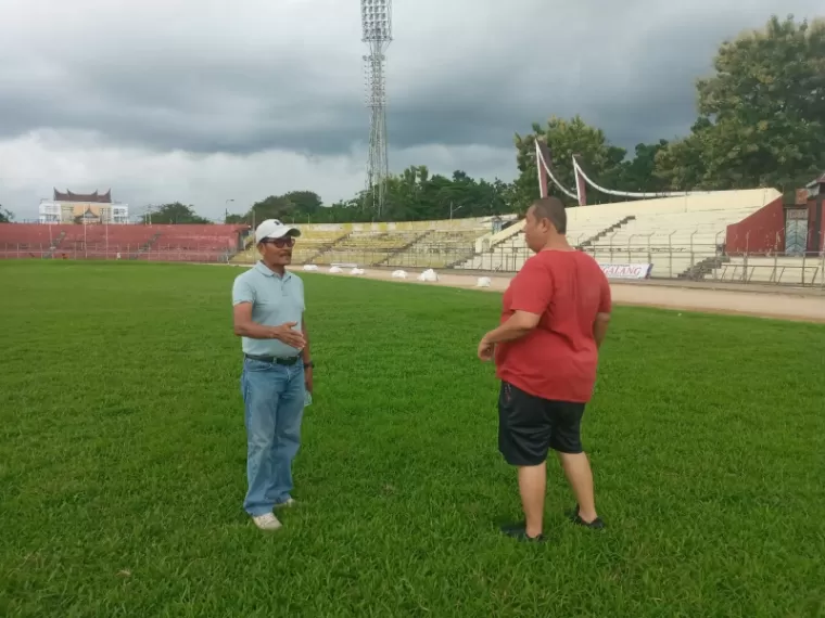 TINJAU - Supomo Hariyadi (kiri) berbincang dengan Renol Fadhli saat meninjau kondisi terbaru rumput Stadion H. Agus Salim, Padang, Selasa (11/6) sore. (dede amri)