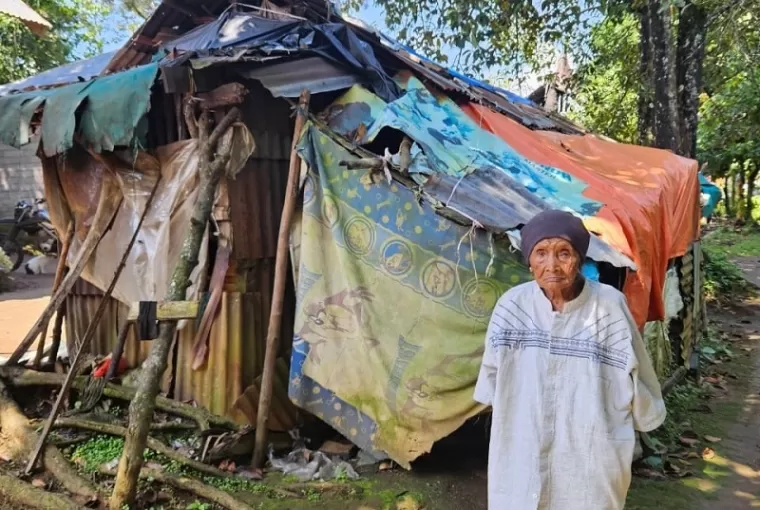 Nenek Nurbaina di depan rumahnya yang tidak layak huni. (ist)