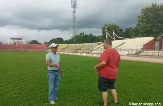 TINJAU - Supomo Hariyadi (kiri) berbincang dengan Renol Fadhli saat meninjau kondisi terbaru rumput Stadion H. Agus Salim, Padang, Selasa (11/6) sore. (dede amri)
