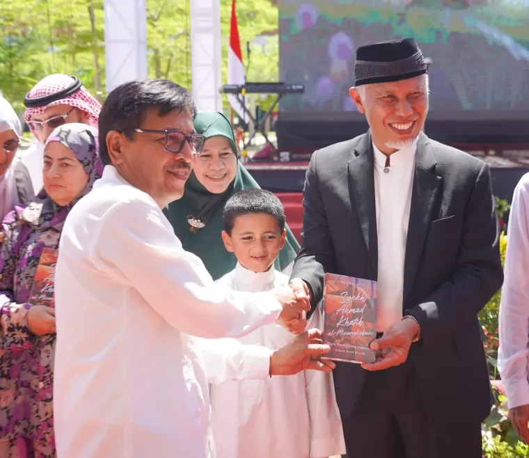 Penulis novel biografi Syekh Ahmad Khatib al Minangkabawi Guru Para Ulama Indonesia, Khairul Jasmi menyerahkan buku pada Gubernur Sumbar, Mahyeldi Ansharulla, Minggu (7/7/2024) pada pemberian nama Masjid Raya Sumbar.