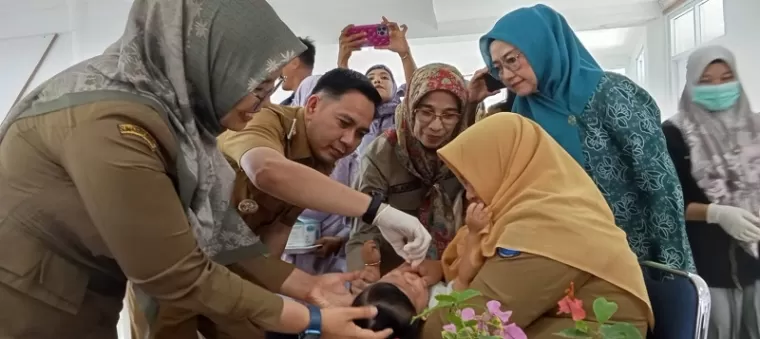 Penjabat Walikota Sawahlunto Fauzan Hasan, Kepala Dinas Kesehatan Ranu Verra Mardianti dan Sekda Ambun Kadri tengah meneteskan vaksin polio pada balita.(armadison)