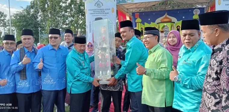 Adri Warman menyerahkan piala brgilir juara umum MTQ tingkat Kabupaten Agam ke-41 kepada Camat Tilatang Kamang, Mhd. Noviadi Ismail. (Maswir Chaniago)