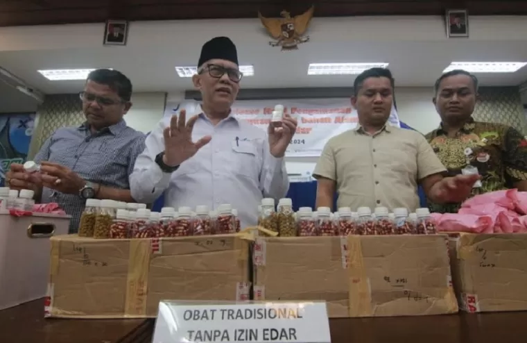 Kepala BBPOM Padang, Drs.Abdul Rahim bersarama jajaran Polda Sumbar memperagakan ratusan botol jamu pelangsing dan jami montok ilega yang diamankan petugas dari salah satu rumah di Padang. Yuke