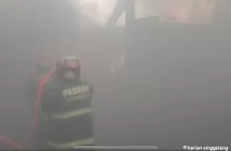 Petugas pemadam kebakaran tengah memadamkan api di gudang Olympic di Simpang Lalang RT 001 RW 002, Batang Kabung, Koto Tangah sekitar pukul 14.40 WIB.