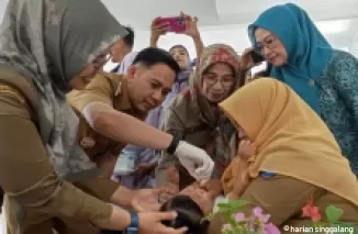 Penjabat Walikota Sawahlunto Fauzan Hasan, Kepala Dinas Kesehatan Ranu Verra Mardianti dan Sekda Ambun Kadri tengah meneteskan vaksin polio pada balita.(armadison)