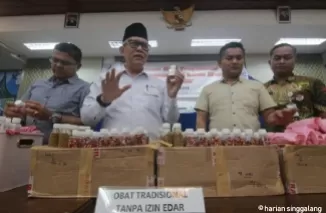 Kepala BBPOM Padang, Drs.Abdul Rahim bersarama jajaran Polda Sumbar memperagakan ratusan botol jamu pelangsing dan jami montok ilega yang diamankan petugas dari salah satu rumah di Padang. Yuke