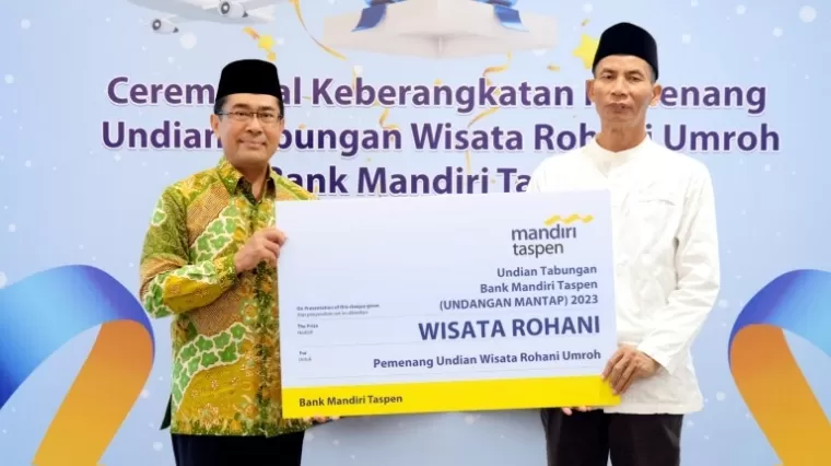 Direktur Bisnis Bank Mandiri Taspen, Maswar Purnama (kiri, baju batik) menyerahkan giant check kepada perwakilan Pemenang Undian Wisata Rohani Umroh di Jakarta sebelum memberangkatkan mereka ke tanah suci.(ist)