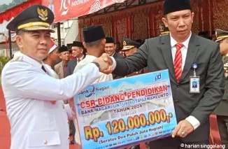 Pimpinan Bank Nagari Cabang Sawahlunto, Rusdi menyerahkan CSR Pendidikan kepada penjabat Walikota Fauzan Hasan di Hari Kemerdekaan Indonesia Ke-79 di Lapangan Ombilin. (armadison)