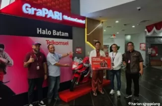 Adittya Pratama (tengah) resmi menjadi pemenang hadiah motor sport program Undi Undi Hepi Periode 4 dari Telkomsel yang diserahkan oleh Manager Mobile Consumer Branch Batam, Muhammad Syahrir di GraPARI Batam Center (22/08).