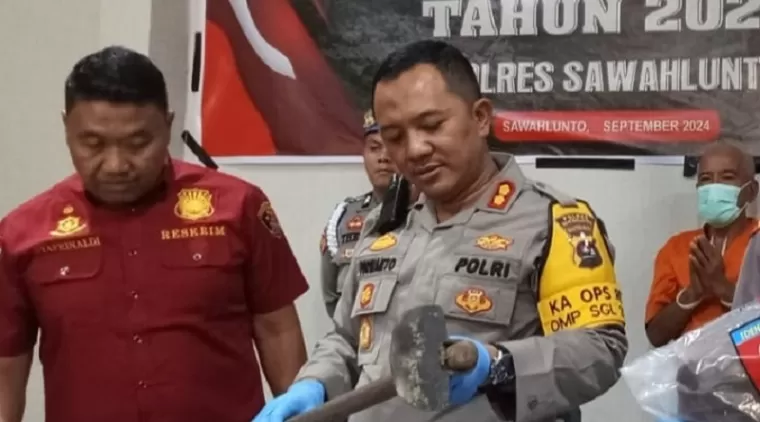 Kapolres Sawahlunto AKBP Purwanto Hari Subekti dan Kasat Reskrim AKP Syafrinaldi tengah memperlihatkan cangkul yang digunakan SH untuk membunuh Rudi Hartono.(armadison)