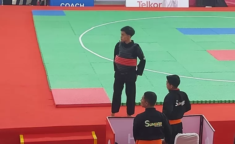 Muhammad Iqbal yang sukses meraih tiket semifinal nomor laga kelas A Putra. Iqbal bersama pelatih Syahripal Effendi. (doc panpel pon sumbar)