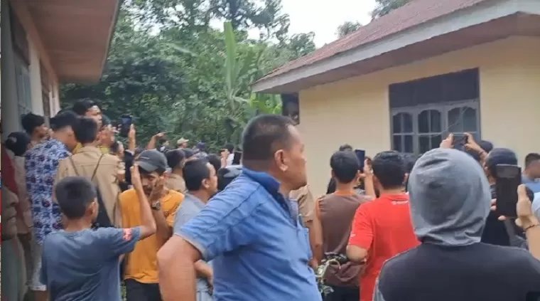 Warga yang geram mengepung rumah kosong yang menjadi tempat persembunyian 'IS'. (ist)