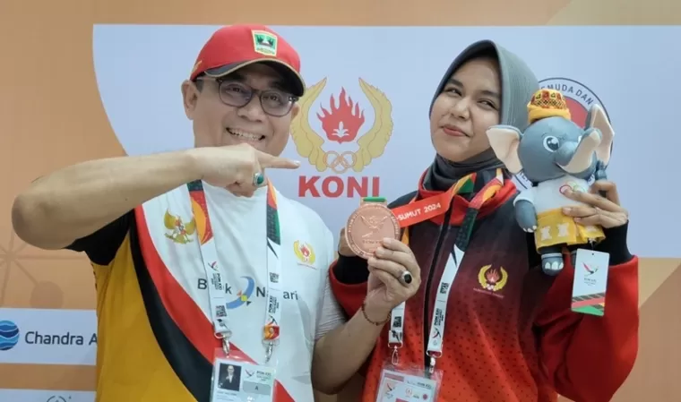 Nadira Adilawati (kanan) bersama Ketua Umum KONI Sumbar, Ronny Pahlawan usai penggalungan medali cabor Hapkido, Selasa (10/9). (doc panpel pon sumbar)