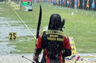 HUJAN LEBAT- Meski hujan lebat, cabor panahan tetap dipertandingkan termasuk pepanah putri Sumbar ini. (humas koni sumbar)