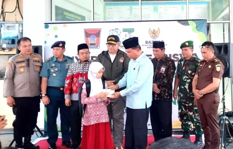 Ketua Baznas Kota Padang, Yuspardi secara simbolis menyerahkan beasiswa dari Baznas Kota Padang pada pelajar SD, Rabu (16/10).Ist