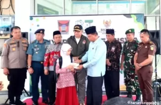 Ketua Baznas Kota Padang, Yuspardi secara simbolis menyerahkan beasiswa dari Baznas Kota Padang pada pelajar SD, Rabu (16/10).Ist