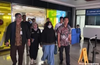 Terpidana Khuslaini (mengenakan masker) bersama tim intelejen Kejagung dan Kejati Sumbar sesampai di Bandara Internasional Minangkabau (BIM) setelah berhasil ditangkap petugas di kawasan Batam, Selasa (1/10).