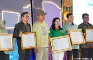 Dirjen Perumahan Kementerian PUPR, Iwan Suprijanto menyerahkan penghargaan pada manajemen PT Semen Padang diwakili Kepala Unit CSR PT Semen Padang Ilham Akbar di GIK UGM (UGM), Sabtu (12/10/2024).Ist