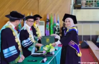 Rektor Unand, Efa Yonnedi menyerahkan ijazah kepada salah satu lulusan yang diwisuda Sabtu (23/11) di auditorium kampus tersebut. (foto: wahyu)