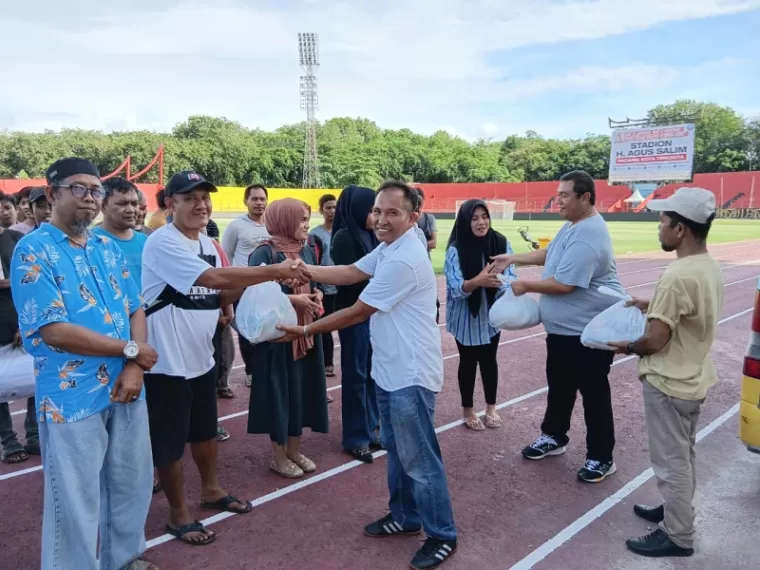 SEMBAKO - Utusan dari Andre Rosiade menyerahkan secara simbolis paket sembako kepada Ketua Panpel Laga Home Semen Padang FC, H. Edri, Senin (9/12) di Stadion H. Agus Salim, Padang. (dede amri)