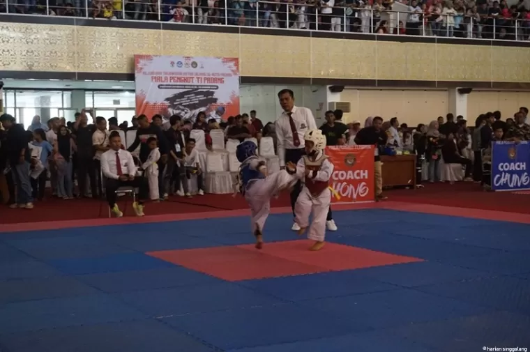 TARUNG - Dua taekwondoin usia dini bertarung di Kejuraan Taekwondo Antar-Dojang se-Kota Padang di Auditorium Unand Kampus Limau Manis, Sabtu (28/12). (ist)