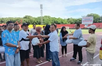 SEMBAKO - Utusan dari Andre Rosiade menyerahkan secara simbolis paket sembako kepada Ketua Panpel Laga Home Semen Padang FC, H. Edri, Senin (9/12) di Stadion H. Agus Salim, Padang. (dede amri)