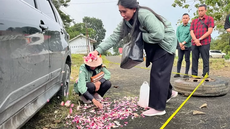 Ibunda Kompol Anumerta Ryanto Ulil Anshar menabur bunga di lokasi penembakan usai rekonstruksi, Kamis kemarin.  (Deri Oktazulmi)