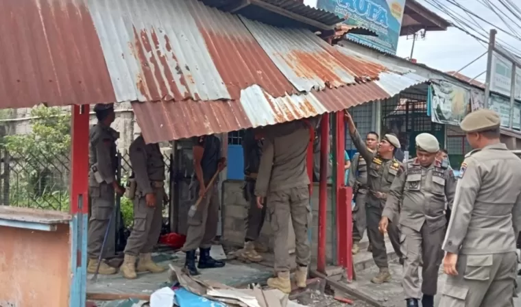 Petugas Satpol PP Padang membongkar bangunan liar di kawasan Kecamatan Lubeg, Kota Padang, pada Kamis (2/1). (ist)