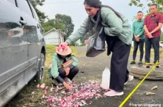 Ibunda Kompol Anumerta Ryanto Ulil Anshar menabur bunga di lokasi penembakan usai rekonstruksi, Kamis kemarin.  (Deri Oktazulmi)