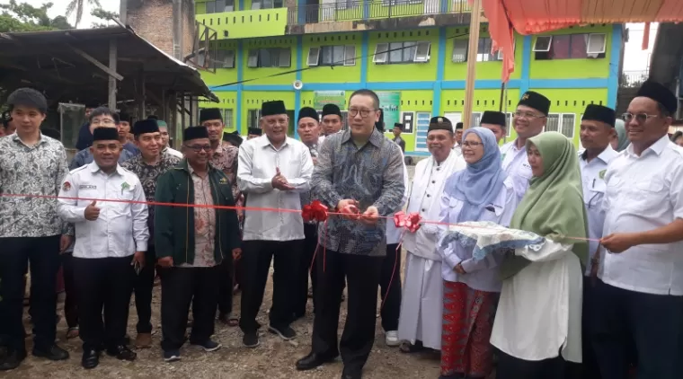 Duta Besar Tiongkok diwakili Konselor Politik, Mr. Zhen Wangda menggunting pita tanda peresmiab asrama santri PPMTI Bantang Kabung bantuan pemerintah Tiongkok. (Bambang)