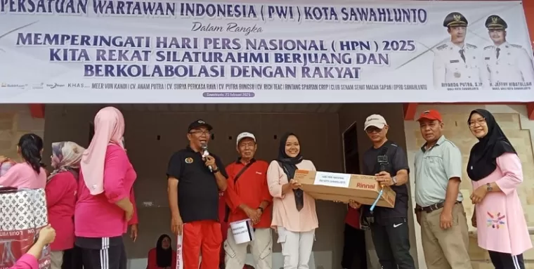 Ketua PWI Sawahlunto Indra Yosep Datmy menyerahkan door prize kepada salah seorang peserta senam massal.(armadison)