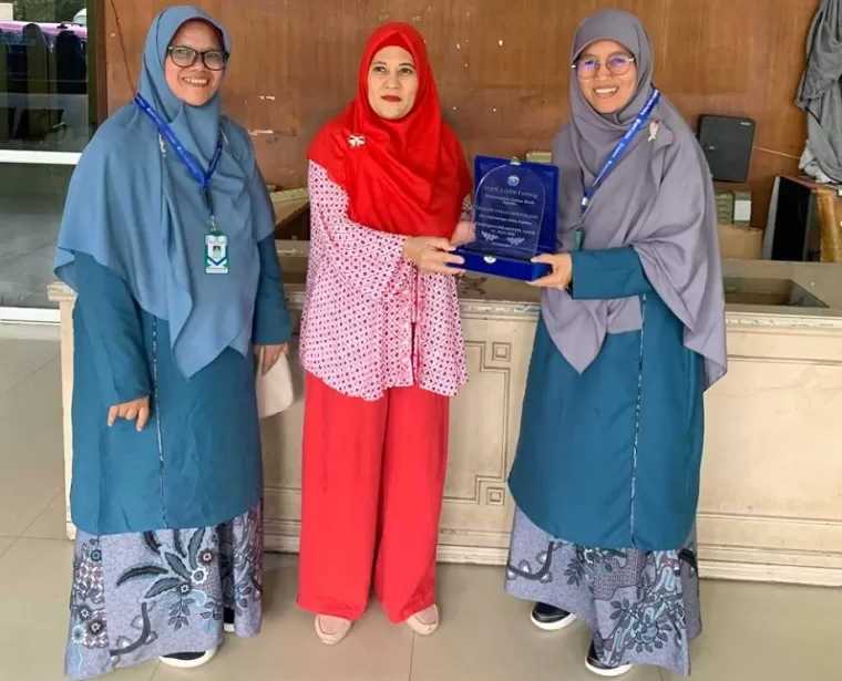 Pemimpin Perusahaan Harian Singgalang, Hj. Rilianty menerima plakat dari ustazah SMPIT Adzkia saat melakukan studi edukasi bersama siswa-siswi SMPIT Adzkia ke Harian Singgalang. ist  Siswa SMPIT Adzkia Studi Edukasi ke Harian Singgalang