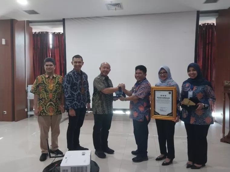 Direktur Teknologi Informasi BPJS Kesehatan, Dr. Ir. Edwin Aristiawan, M.M. serahkan penghargaan pada Direktur Utama SPH dr. Selfi Farisha dan didampingi oleh Ketua Yayasan Semen Padang, Amral Ahmad serta Direktur Operasional SPH dr. Adisty Taufik, di SPH