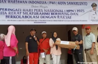 Ketua PWI Sawahlunto Indra Yosep Datmy menyerahkan door prize kepada salah seorang peserta senam massal.(armadison)