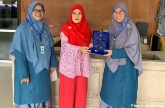 Pemimpin Perusahaan Harian Singgalang, Hj. Rilianty menerima plakat dari ustazah SMPIT Adzkia saat melakukan studi edukasi bersama siswa-siswi SMPIT Adzkia ke Harian Singgalang. ist  Siswa SMPIT Adzkia Studi Edukasi ke Harian Singgalang