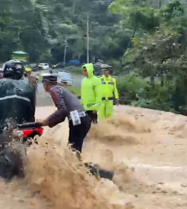 Personil Satlantas Polres Limapuluh Kota bantu pengendara motor melintas di ruas Jalan Sumbar-Riau tepatnya di Km 17 Pangkalan.(Ist)