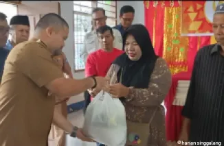 Wakil Walikota Jeffry Hibatullah menyerahkan paket bahan pokok kepada salah seorang warga tidak mampu didampingi General Manager PTBA-UPO Yulfaizon.(armadison)