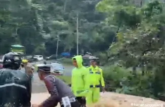 Personil Satlantas Polres Limapuluh Kota bantu pengendara motor melintas di ruas Jalan Sumbar-Riau tepatnya di Km 17 Pangkalan.(Ist)